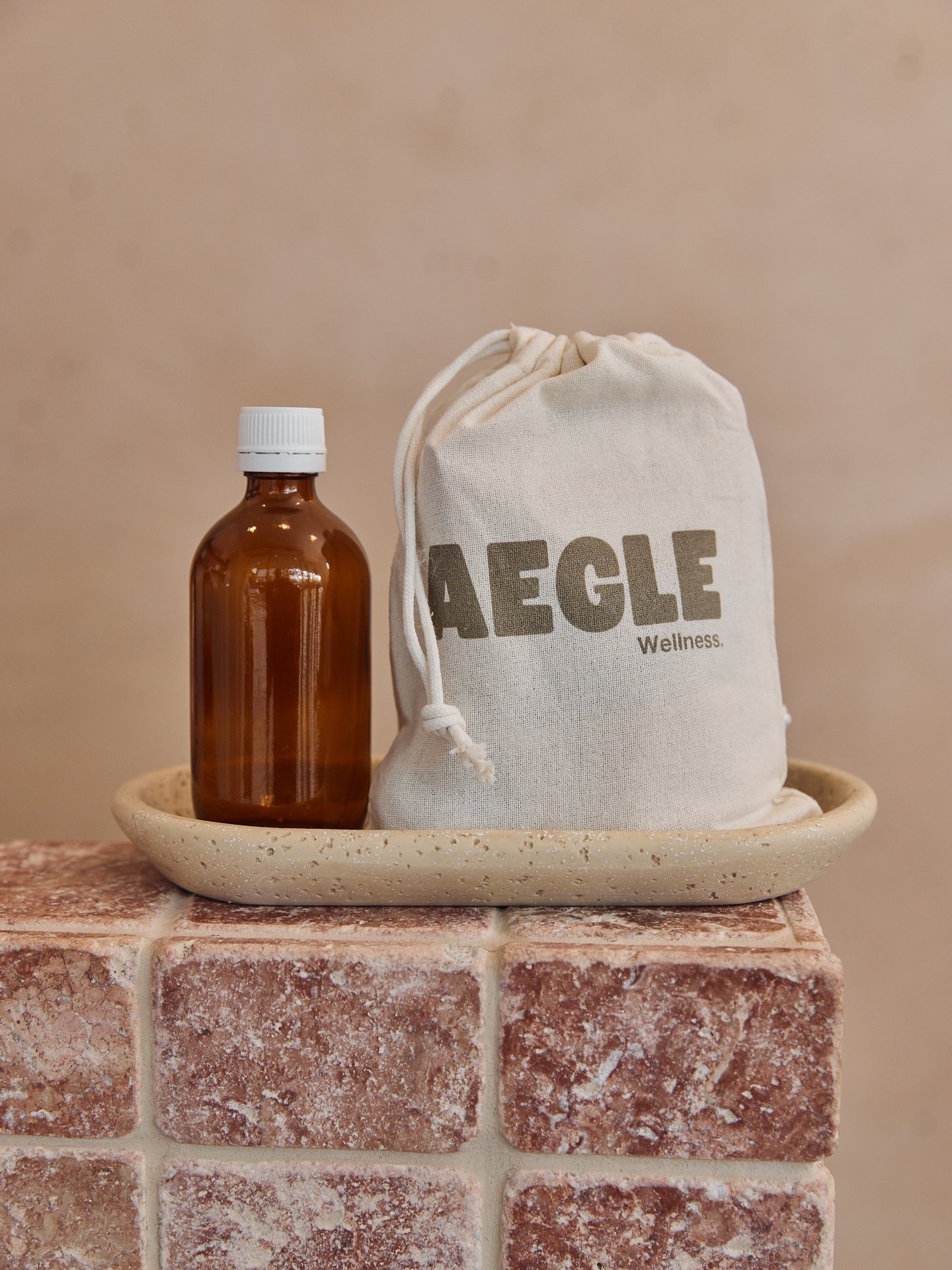 An Aegle Wellness bag and amber tonic bottle
